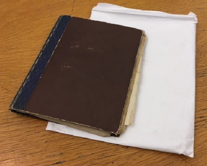 An image of Ellis' brown notebook, which he filled with his drawings of magnified organisms. The notebook is kept in a protective envelope.