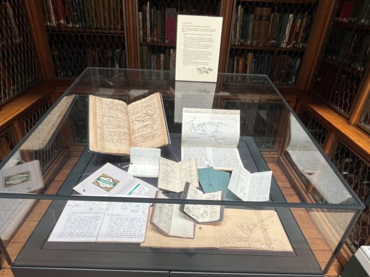 A glass exhibition case with archival items inside