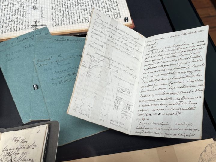 Opened up pages of a journal showing handwritten text and pencil-drawn sketches