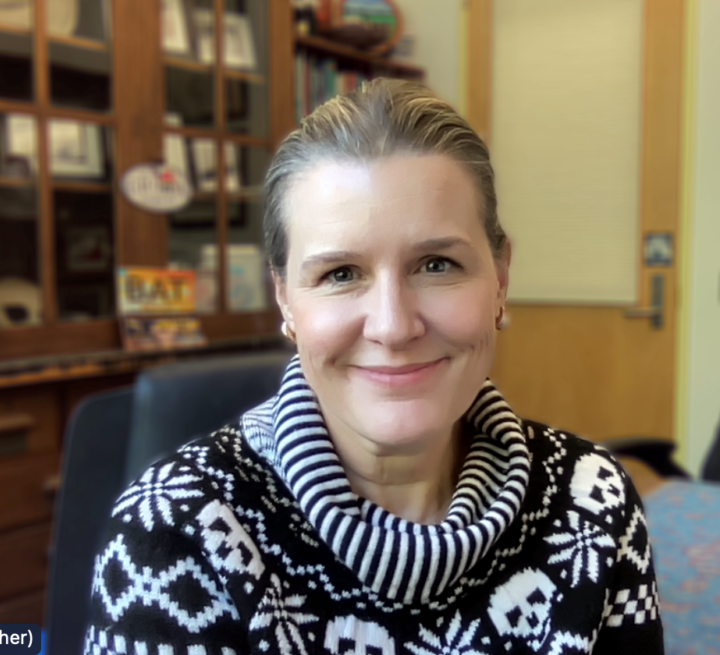 Dr Karen Sears in front of a shelf of artefacts