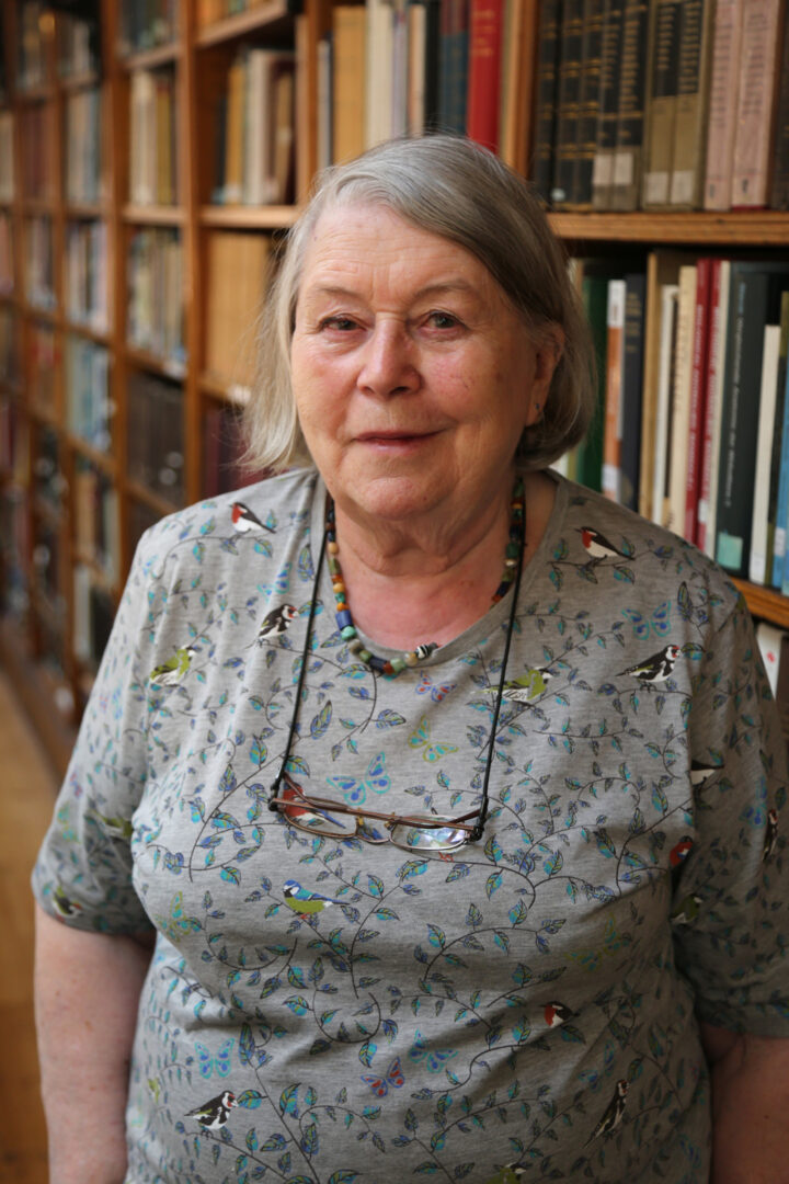 Lady standing in front of bookshelves.