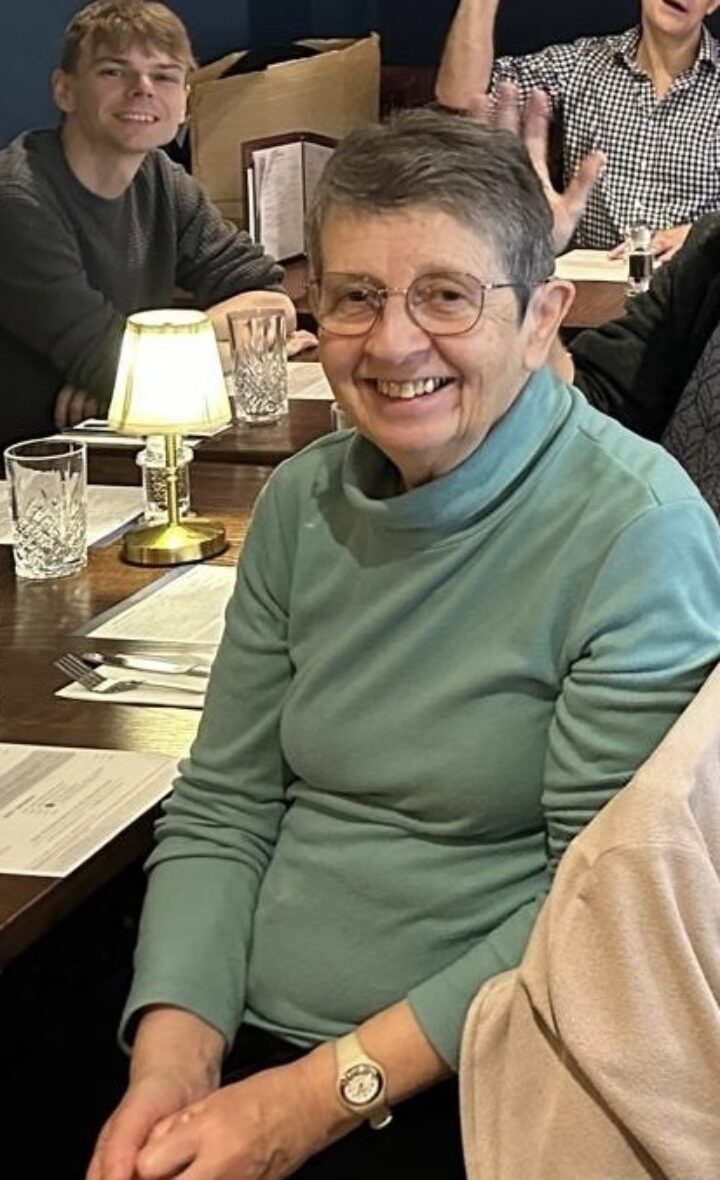 A woman in a blue jumper sat at a table
