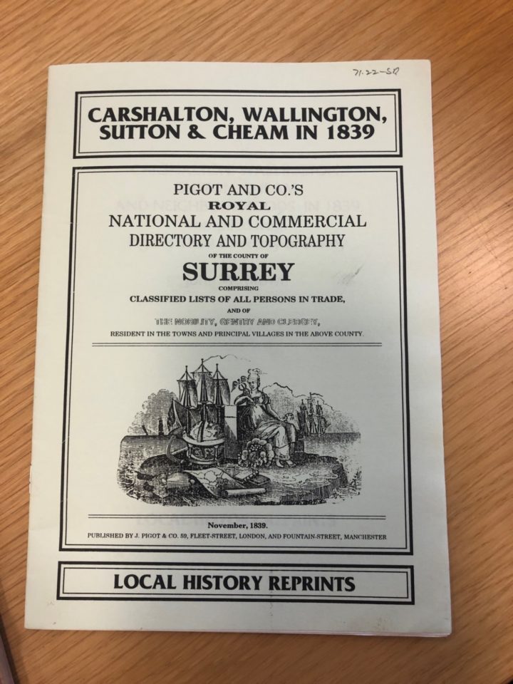 A booklet on the National and Commercial Directory and Topography of Carshalton, Wallington, Sutton & Cheam in 1839. The booklet shows an image of Britannia sitting in front of a ship leaning surrounded by a cornicopia, globe and maps.