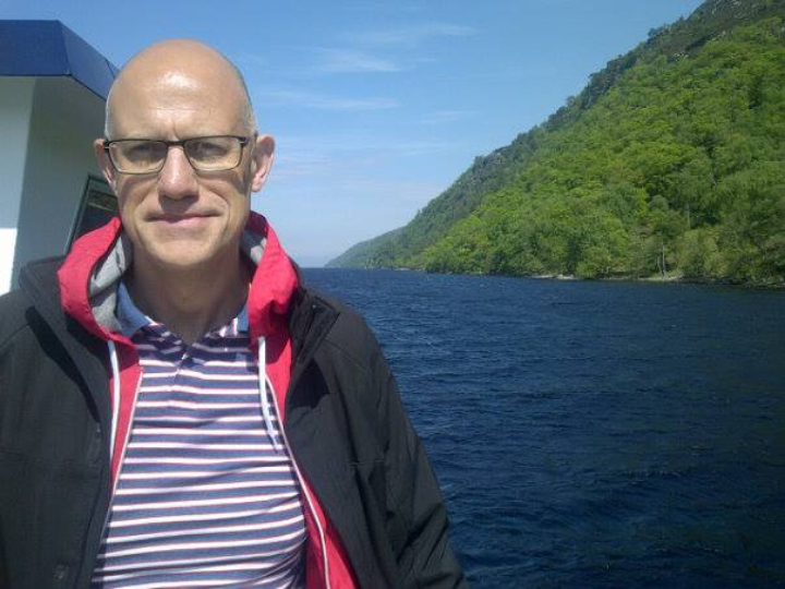 Photo portrait of Glenn Benson, stood by the sea
