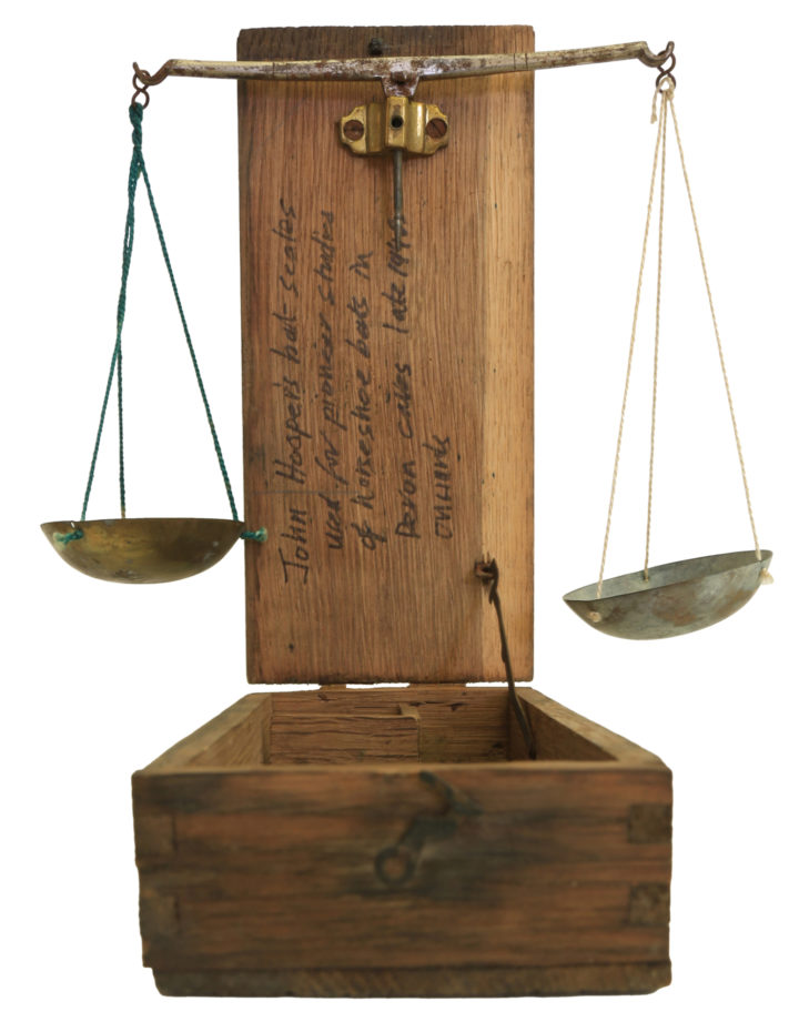 The bat scales in action. Small re-purposed apothecary scales, with two weight balances hung on the lid.