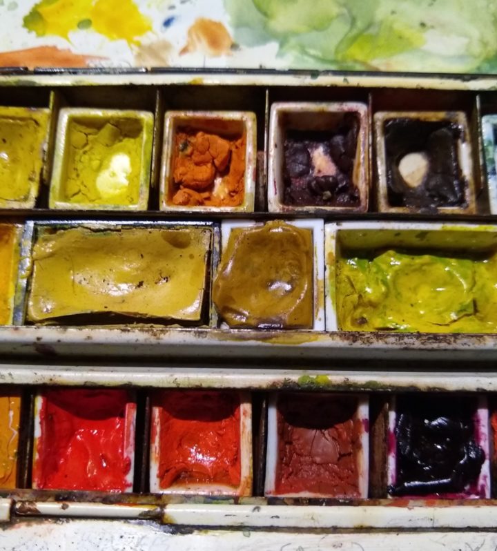 Close up of watercolour paint box: orange, brown, yellow