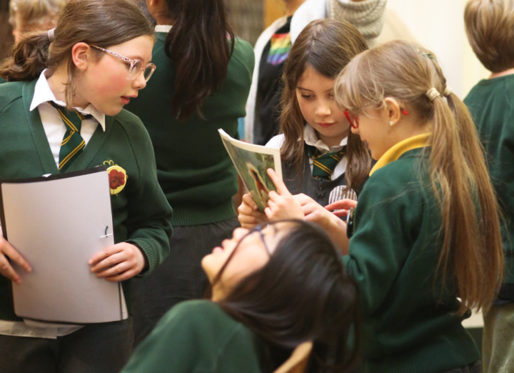 students looking at their nature journals in the library