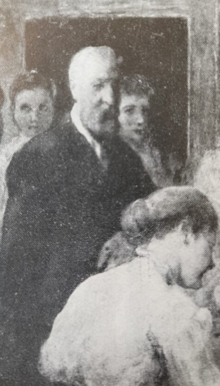 Black and white photograph of detailing in the Sant portrait of the admission of women to the Linnean Society. Shows two women in the background, and man standing in front of them watching as a third women signs the roll of Fellows