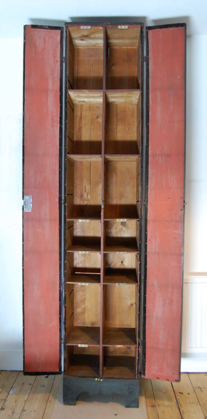 One of the inner cabinets from the previous image, tall and thin with spaces for papers full of pressed plants