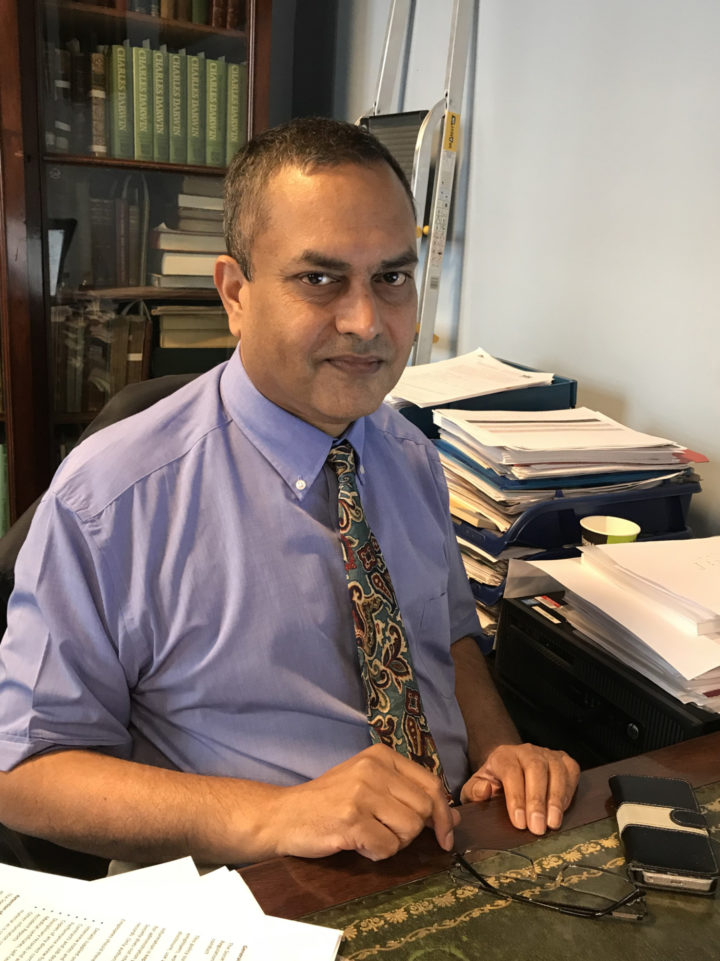 A picture of Priya working at his desk